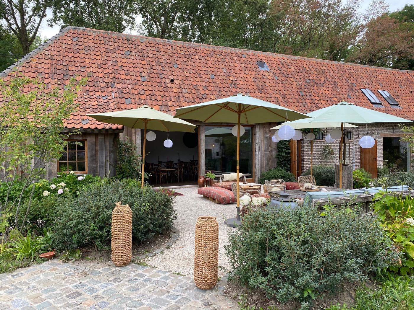 Het binnenplein van Baxus met groene parasols voor de oude schuur
